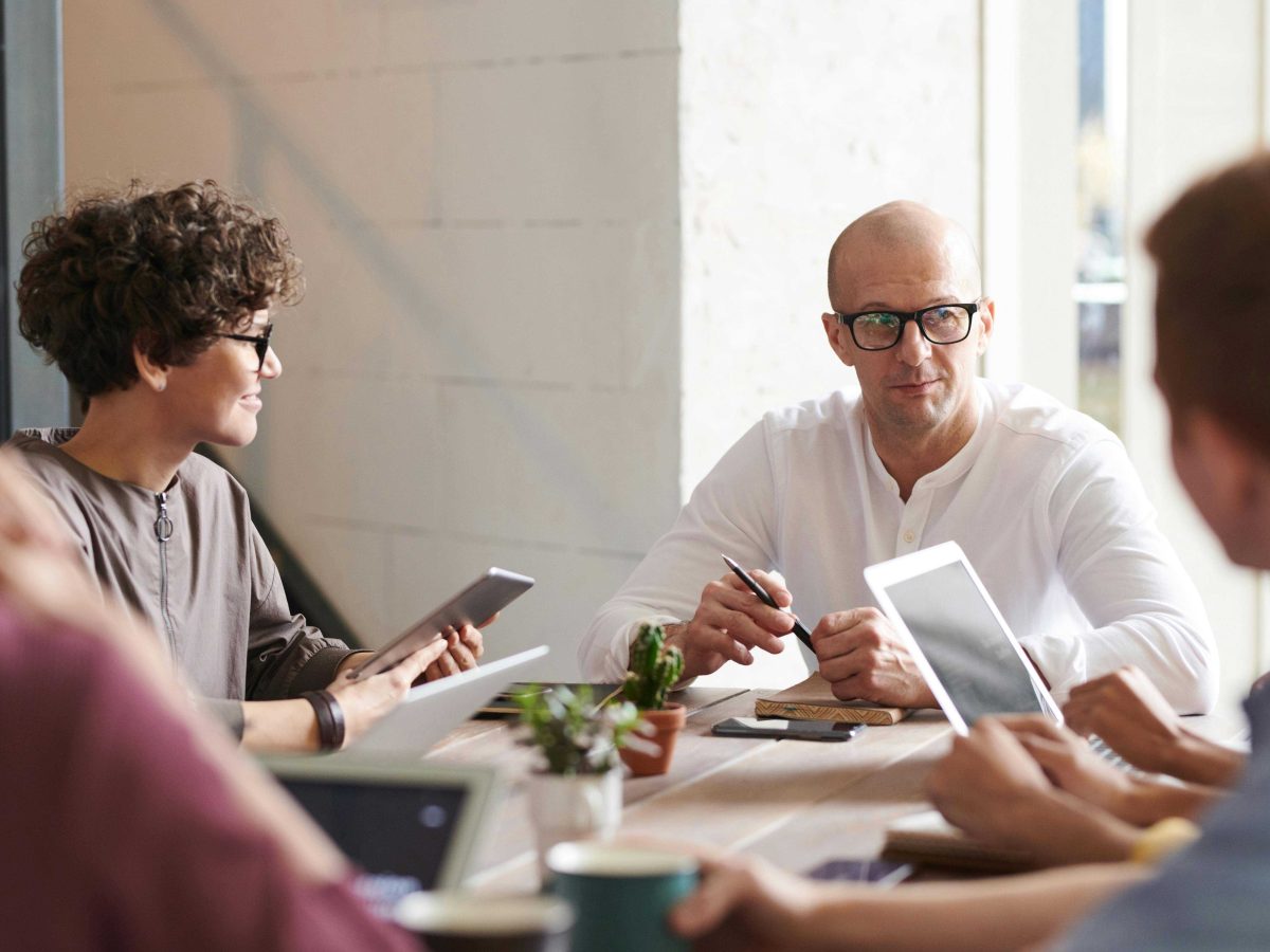 Photo of Man Sitting in Front of People in a Focus Group