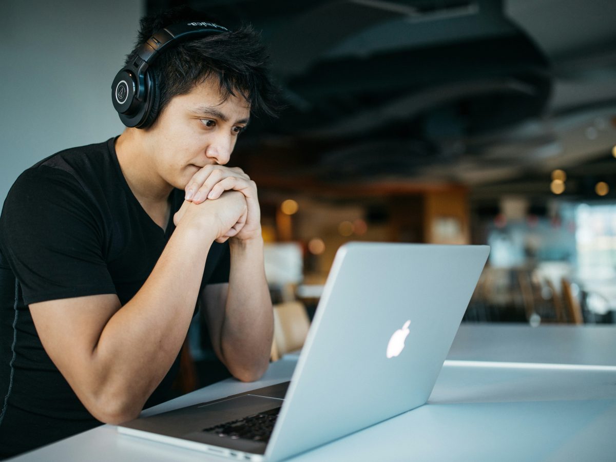 Man watching content on laptop with headphones